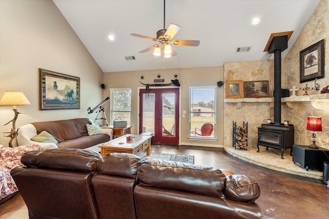 living room with high vaulted ceiling, ceiling fan, and a wood stove