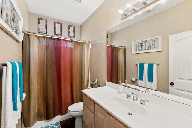 bathroom featuring curtained shower, toilet, and vanity