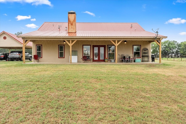 back of property with a lawn and a patio