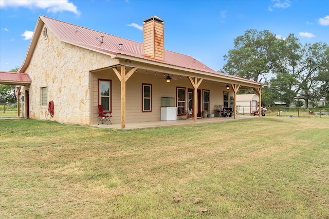 back of property featuring a yard, ceiling fan, and a patio