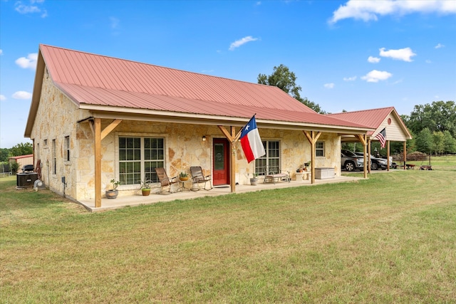 rear view of house with a yard, a carport, and a patio