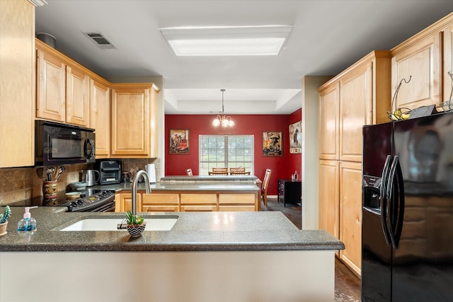 kitchen with black appliances, hanging light fixtures, an inviting chandelier, and kitchen peninsula