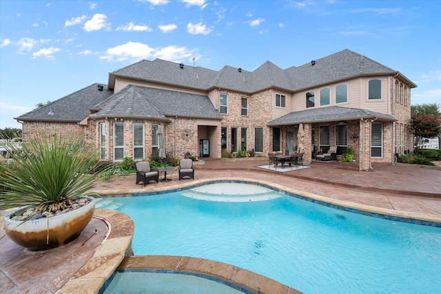 view of pool with a patio area and an in ground hot tub