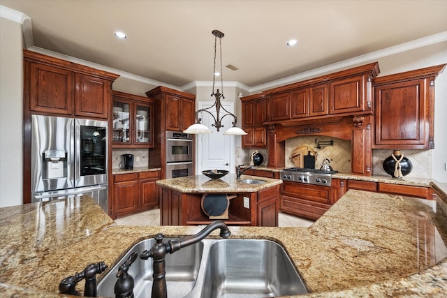 kitchen featuring ornamental molding, stainless steel appliances, decorative light fixtures, decorative backsplash, and a center island with sink