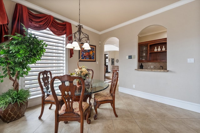 dining area with ornamental molding, a chandelier, and light tile patterned floors