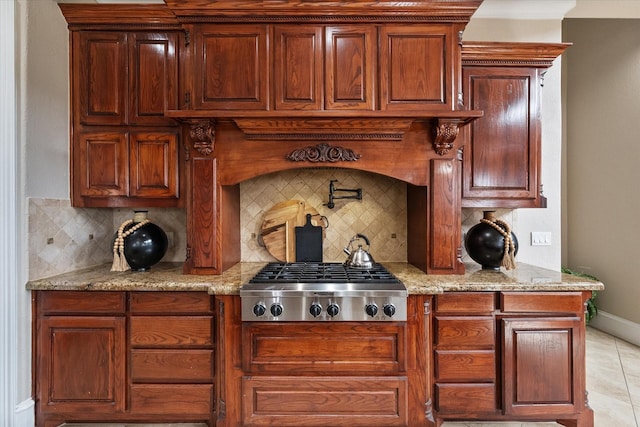 bar with baseboards, light tile patterned flooring, decorative backsplash, and stainless steel gas stovetop