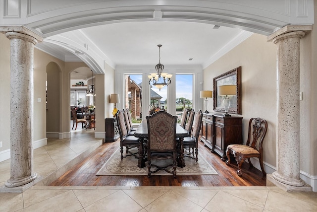 dining area featuring arched walkways, a notable chandelier, decorative columns, and light tile patterned floors