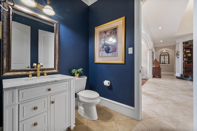 bathroom featuring toilet, tile patterned flooring, crown molding, decorative columns, and vanity