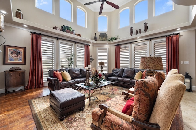 living room featuring ornamental molding, hardwood / wood-style floors, a high ceiling, and ceiling fan