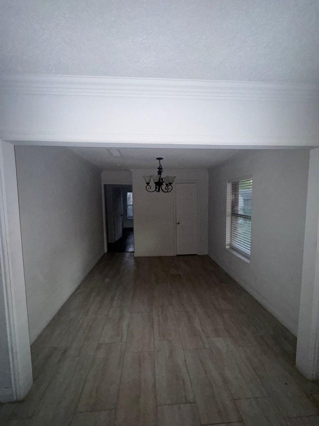 interior space featuring an inviting chandelier, dark hardwood / wood-style flooring, and a textured ceiling