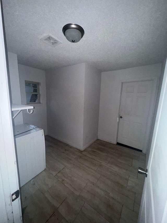 clothes washing area featuring a textured ceiling