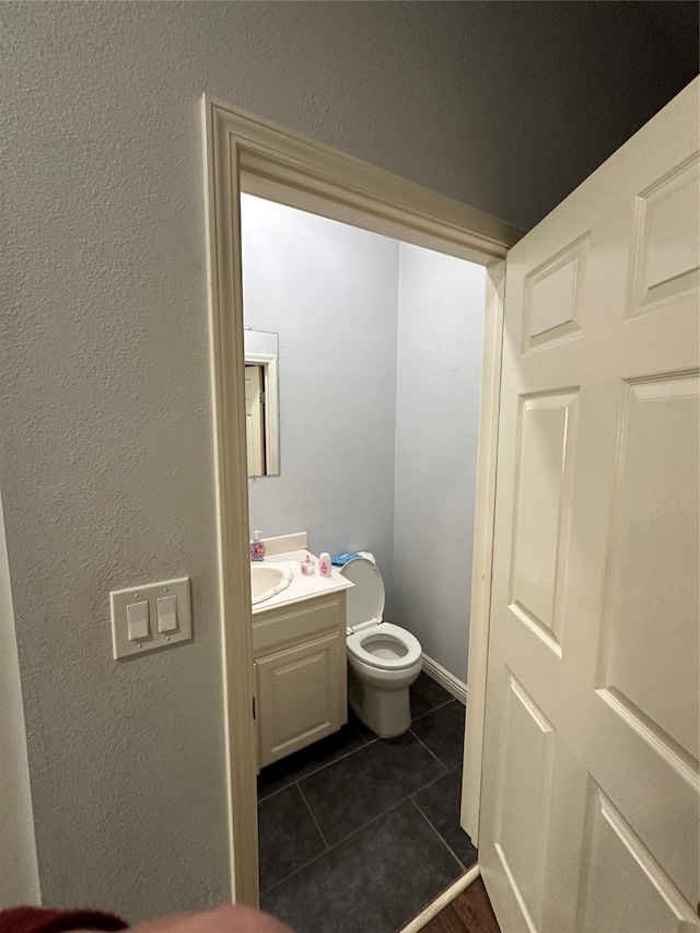 bathroom with vanity, tile patterned flooring, and toilet