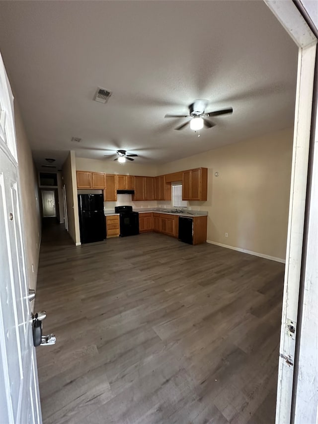 kitchen featuring a textured ceiling, black appliances, dark wood-type flooring, and ceiling fan