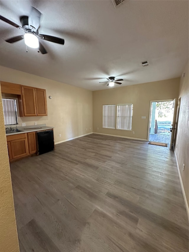 unfurnished living room with hardwood / wood-style flooring, sink, and ceiling fan