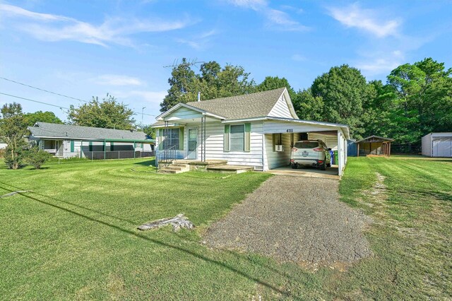 view of front facade featuring a front yard, a carport, and a shed