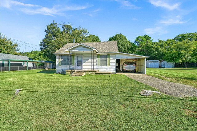 view of front facade with an outdoor structure, a front yard, and a carport