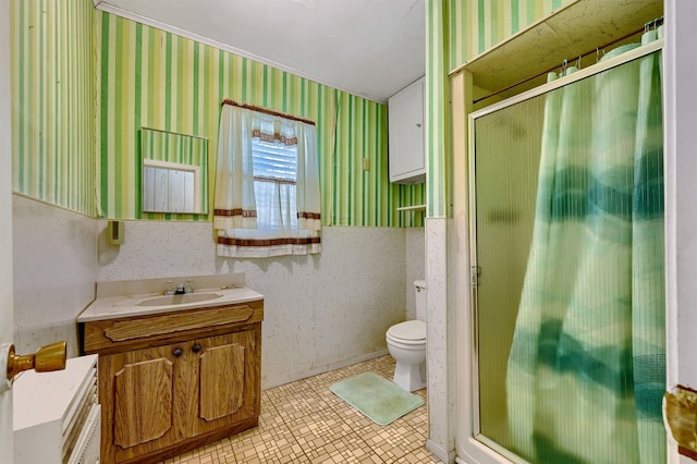 bathroom with vanity, toilet, and a shower with door