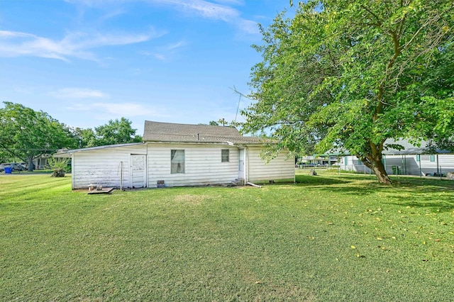 back of property featuring a lawn