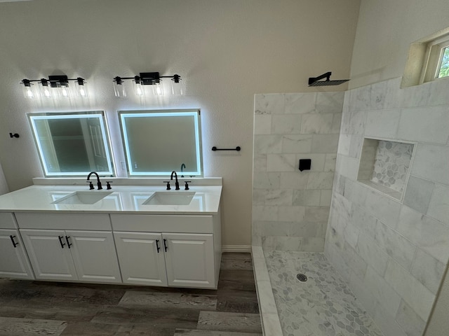 bathroom with vanity, a tile shower, and hardwood / wood-style flooring