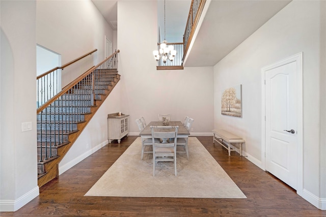 dining room featuring a high ceiling, dark hardwood / wood-style floors, and an inviting chandelier