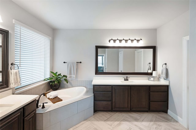 bathroom with vanity and tiled tub