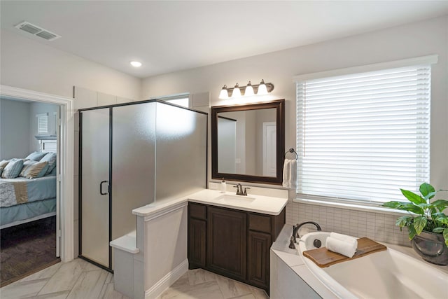 bathroom with plenty of natural light, shower with separate bathtub, and vanity