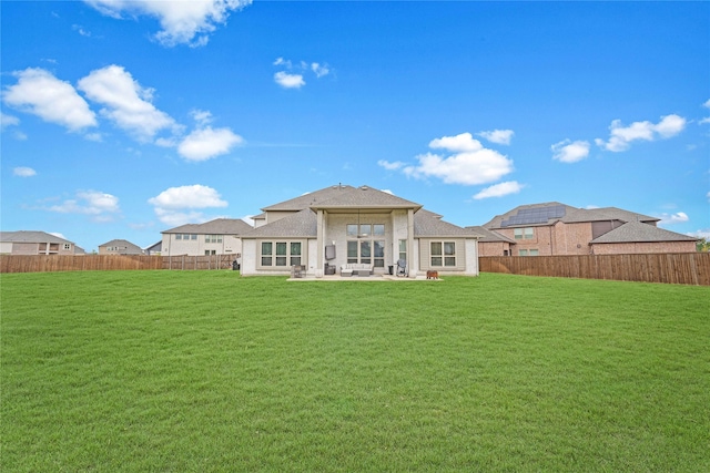 rear view of house featuring a patio area and a yard