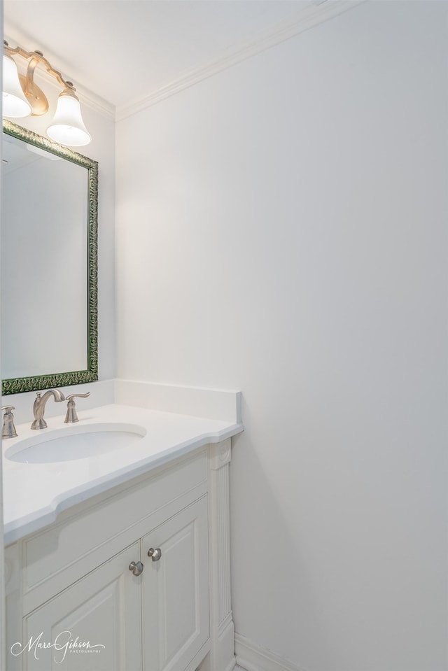 bathroom with ornamental molding, vanity, and baseboards