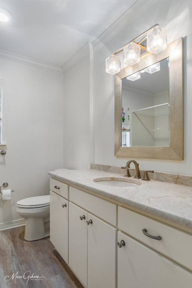 bathroom featuring crown molding, vanity, toilet, and wood finished floors