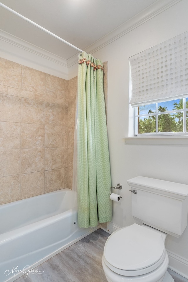 bathroom featuring ornamental molding, shower / tub combo with curtain, hardwood / wood-style floors, and toilet