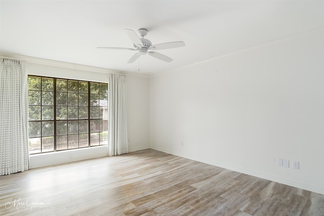 empty room featuring baseboards, wood finished floors, a ceiling fan, and crown molding