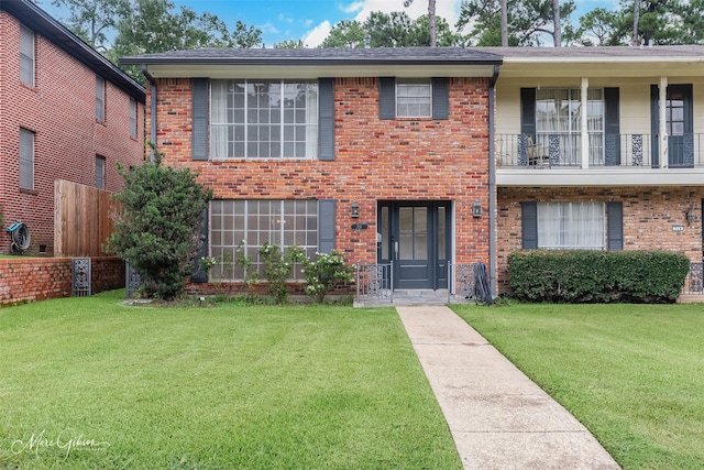 view of front of house featuring brick siding and a front yard