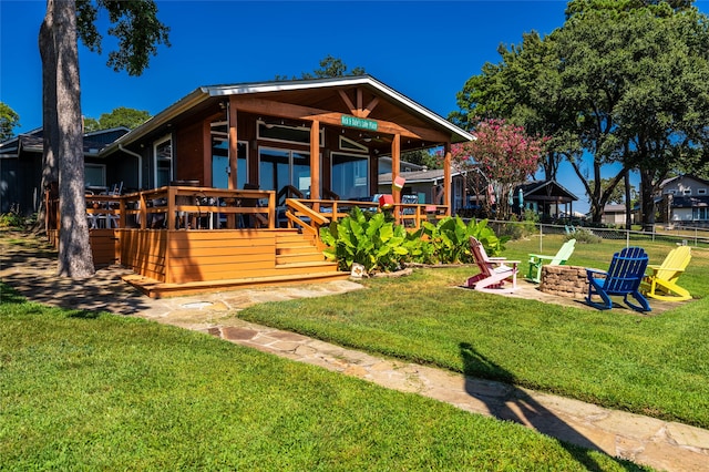 view of front facade featuring a front lawn, a deck, and a fire pit