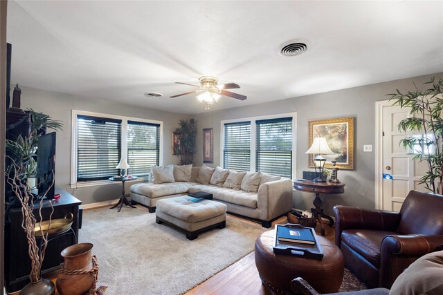 living room featuring a healthy amount of sunlight, ceiling fan, and hardwood / wood-style floors