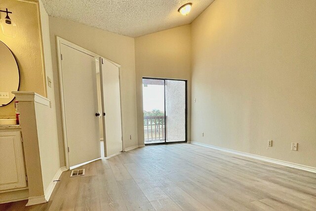 laundry room featuring light hardwood / wood-style flooring, a textured ceiling, and independent washer and dryer