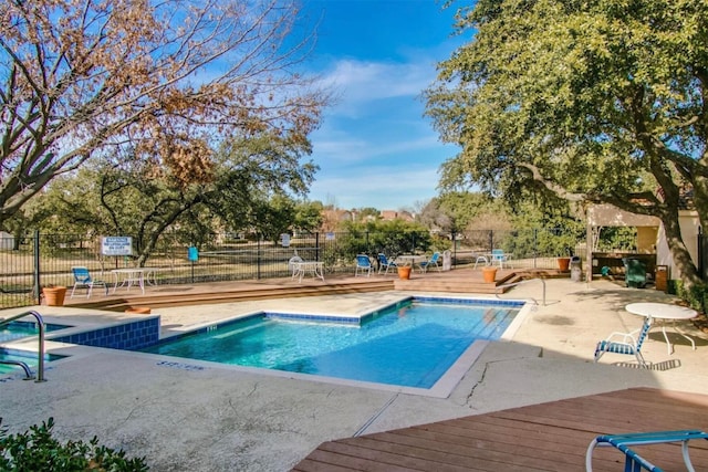 view of pool featuring a patio and a wooden deck