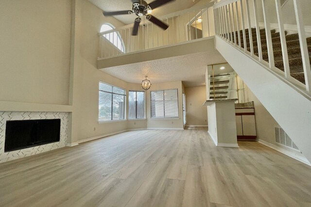 unfurnished dining area featuring hardwood / wood-style floors, a textured ceiling, an inviting chandelier, and plenty of natural light