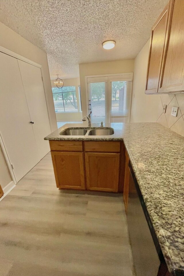 kitchen with kitchen peninsula, tasteful backsplash, a textured ceiling, white appliances, and hardwood / wood-style flooring