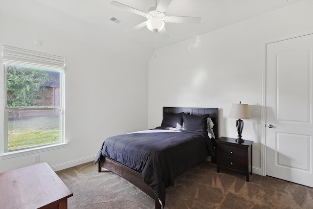 bedroom featuring lofted ceiling, dark carpet, and ceiling fan