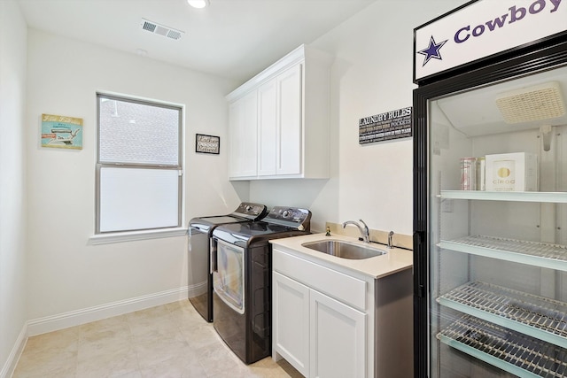 washroom featuring washer and clothes dryer, cabinets, and sink