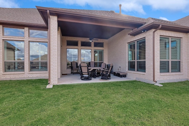 back of house featuring a lawn, ceiling fan, and a patio area