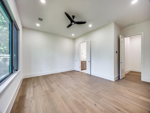 unfurnished bedroom with ceiling fan, light wood-type flooring, and ensuite bathroom