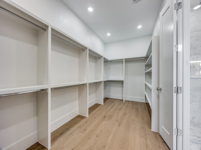 walk in closet with light hardwood / wood-style floors