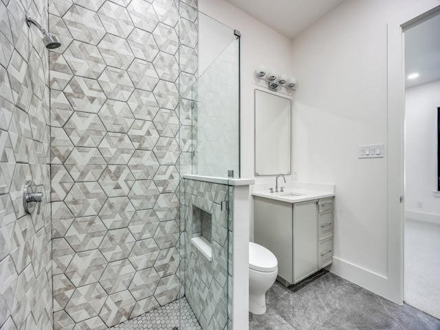 bathroom featuring a tile shower, vanity, and toilet