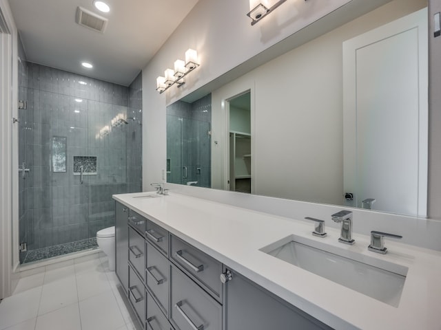 bathroom featuring tile patterned flooring, vanity, a shower with door, and toilet