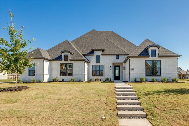 french country inspired facade featuring a front lawn