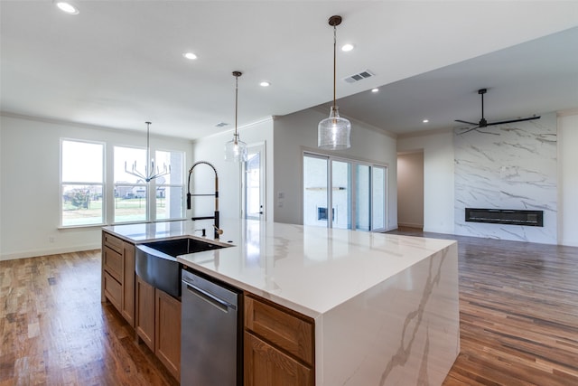 kitchen with a large island, a high end fireplace, dishwasher, dark hardwood / wood-style floors, and decorative light fixtures