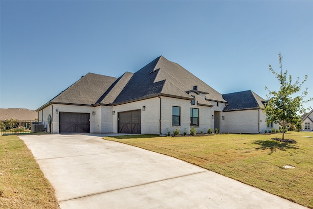 french country inspired facade featuring a garage, cooling unit, and a front lawn