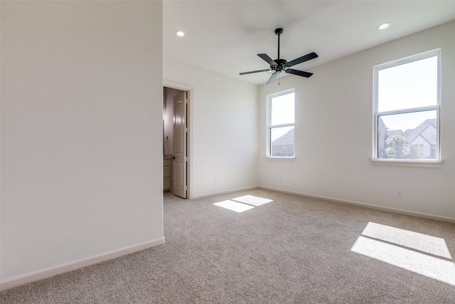 carpeted spare room with ceiling fan