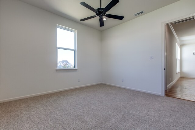 carpeted empty room featuring ceiling fan and crown molding